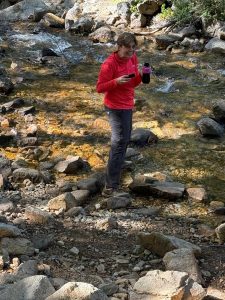 filling-water-bottles-from-a-stream-50-at-50